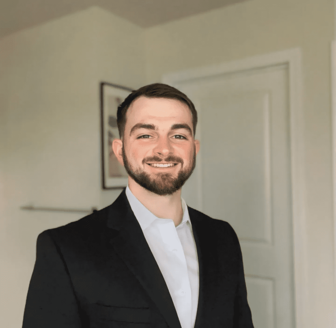 A man in a suit standing next to a door.